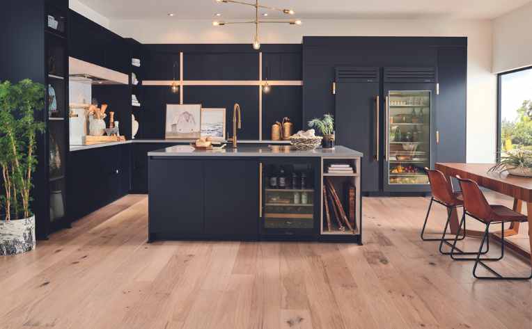 light hardwood floors in modern kitchen with dark blue cabinets