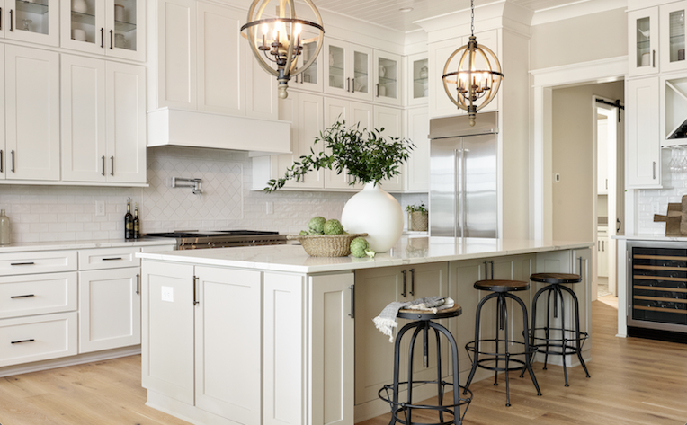 kitchen interior design with white cabinets, wood look floors, and white marble countertops on a center island