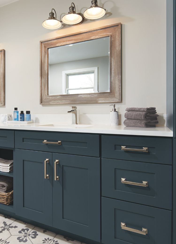 bathrooom vanity with two sinks, mirrors, and stylish blue cabinetry 