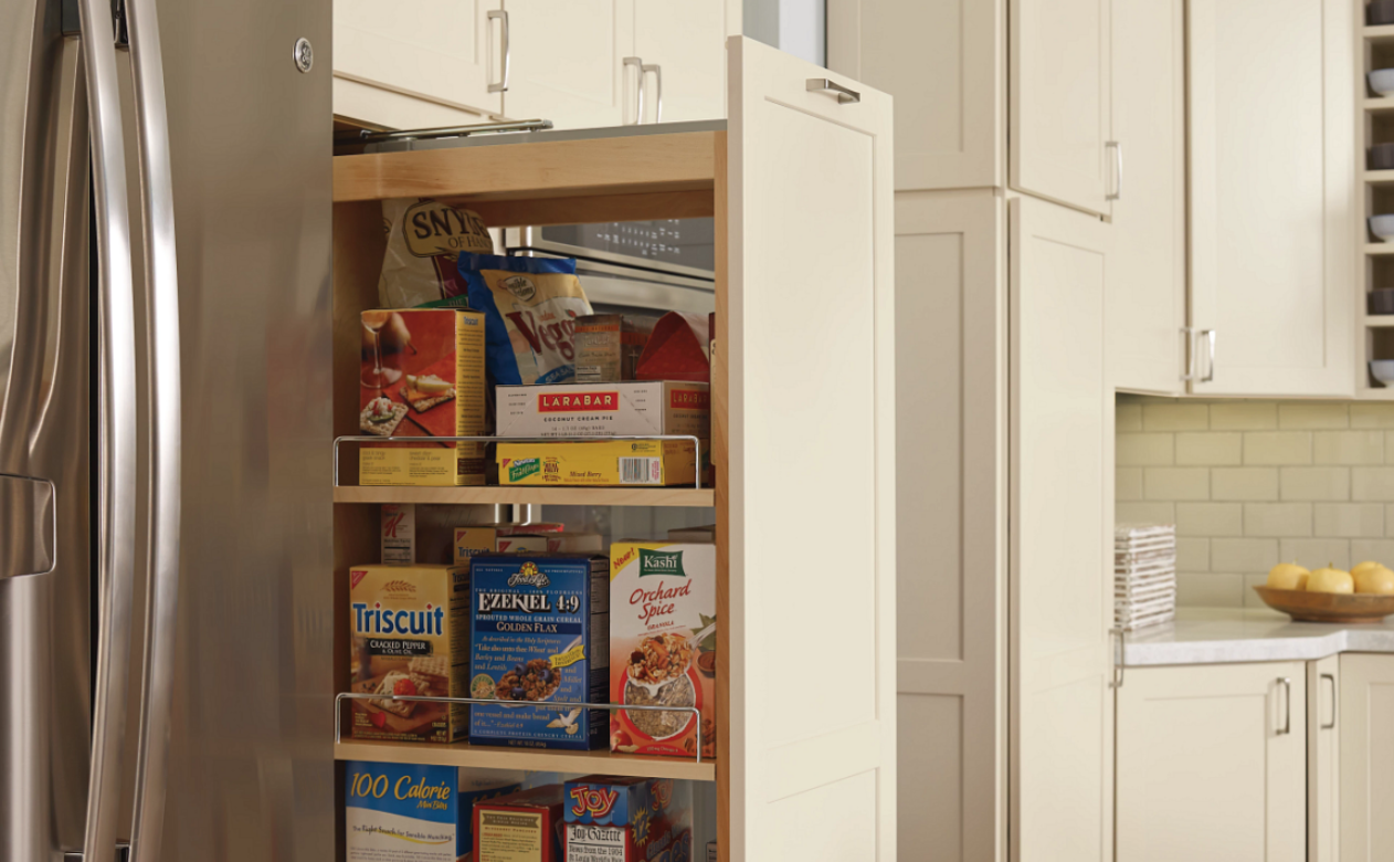 Functional kitchen design featuring a stocked pull-out pantry and stainless steel appliances.