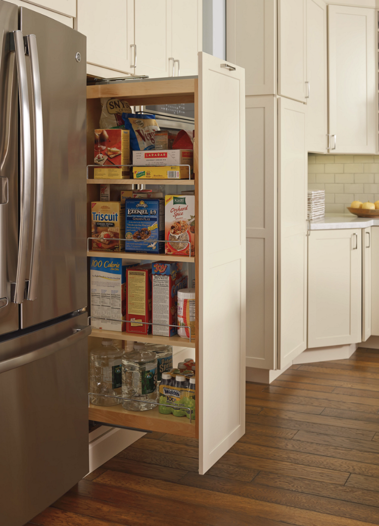 Functional kitchen design featuring a stocked pull-out pantry and stainless steel appliances.
