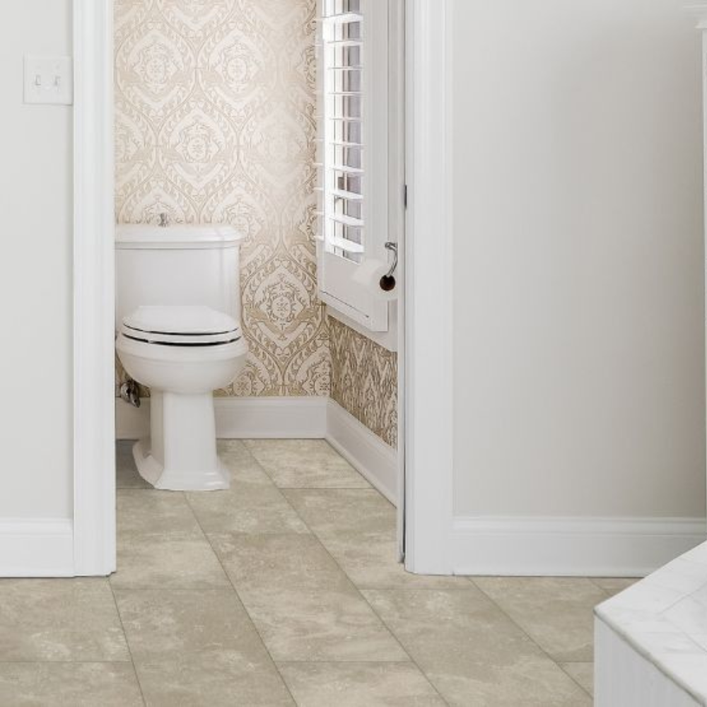 Separate toilet nook with a white toilet, patterned beige damask wallpaper, and a shuttered window.