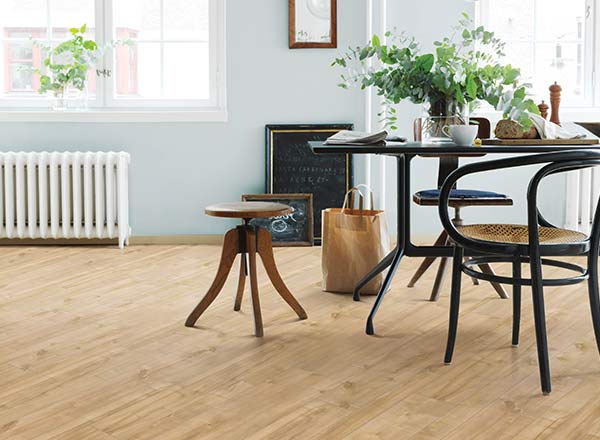 light wood-look floor with blue wall and dark colored chairs and table