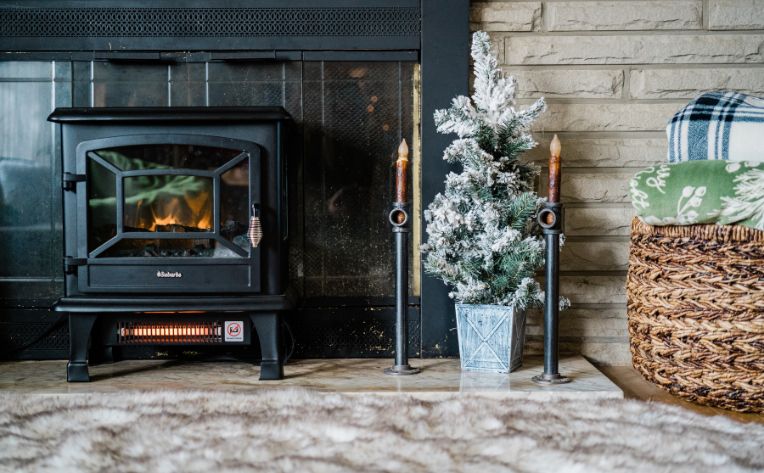 Wood-burning stove surrounding by cozy decorations.