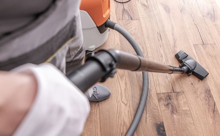 vacuuming hardwood flooring with a soft bristled floor vacuum cleaner