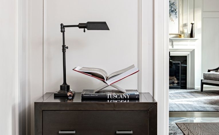 corner of home office with lamp and books on side table