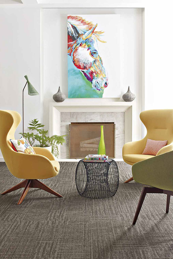 Contemporary modern sitting area with yellow accent chairs and grey carpet 