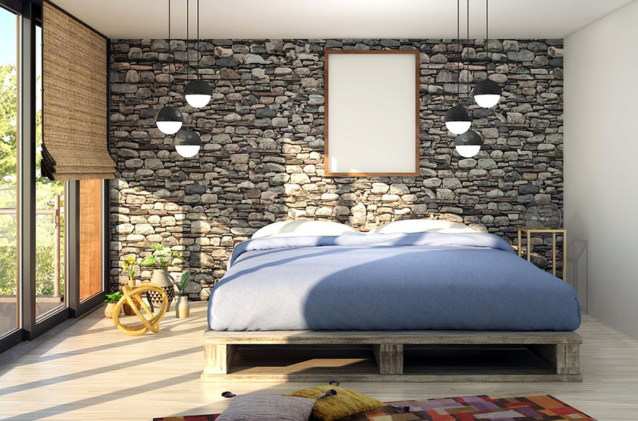 Bedroom with pallet style bed frame and stone wall