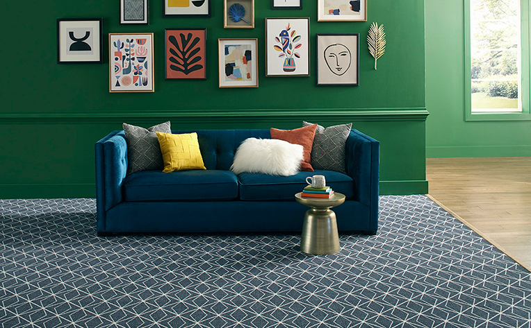 Blue patterned flooring in living room with green gallery walls