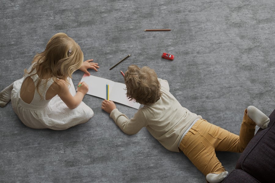 Two children on floor drawing on paper