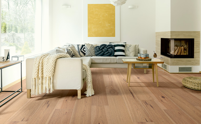 hardwood floor with white couch and white walls